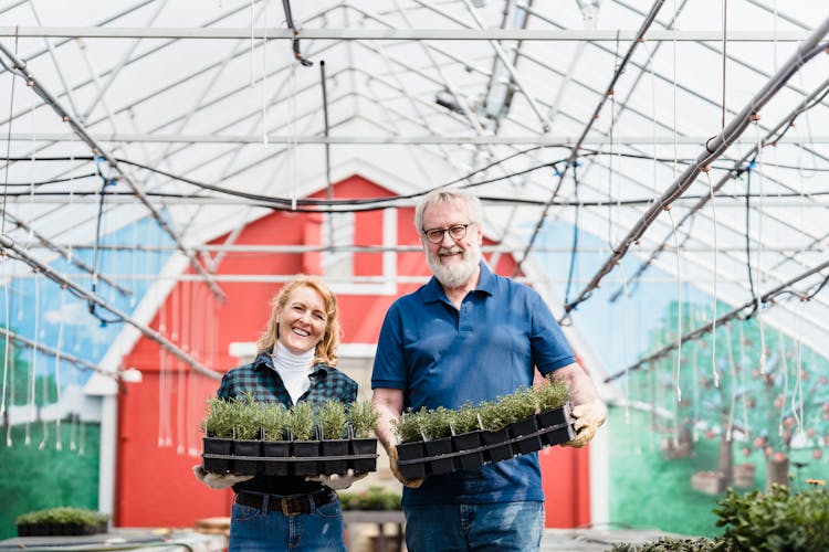 Smiling Couple Of Farmers In Greenhouse