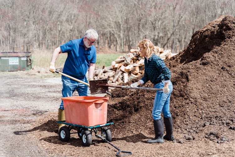 Elderly Couple Shoveling The Soil