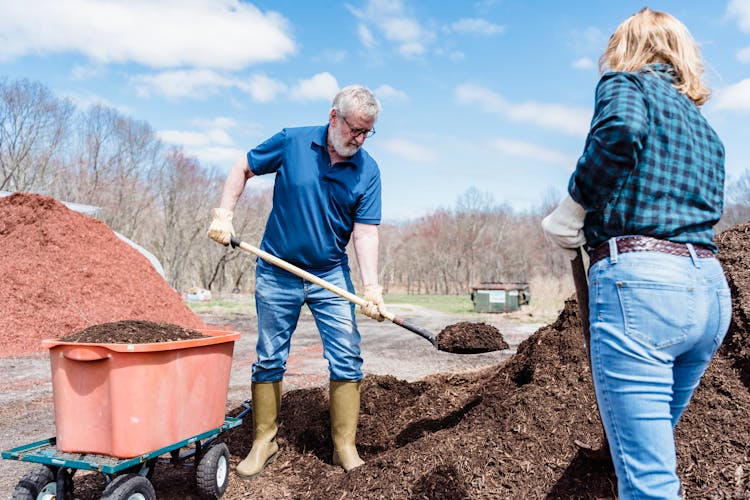 Elderly Couple Shoveling The Soil