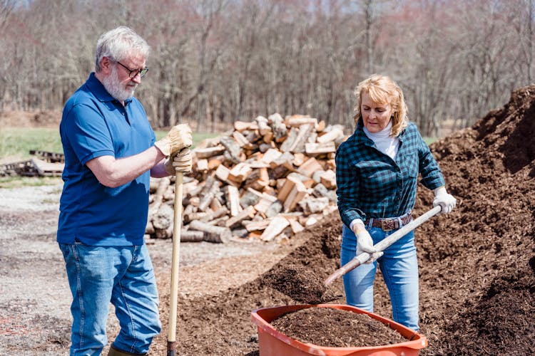 Elderly Couple Shoveling The Soil