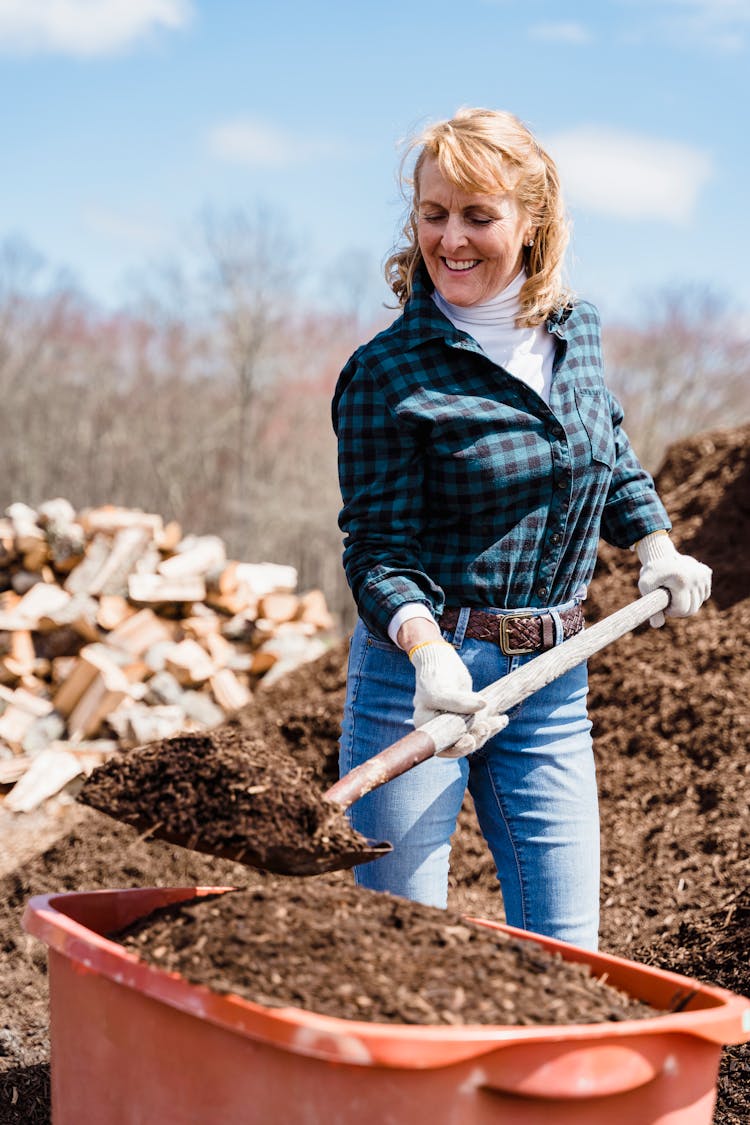 Elderly Woman Shoveling The Soil