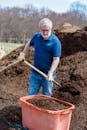 Man in Blue Polo Shirt Holding Brown Wooden Shovel