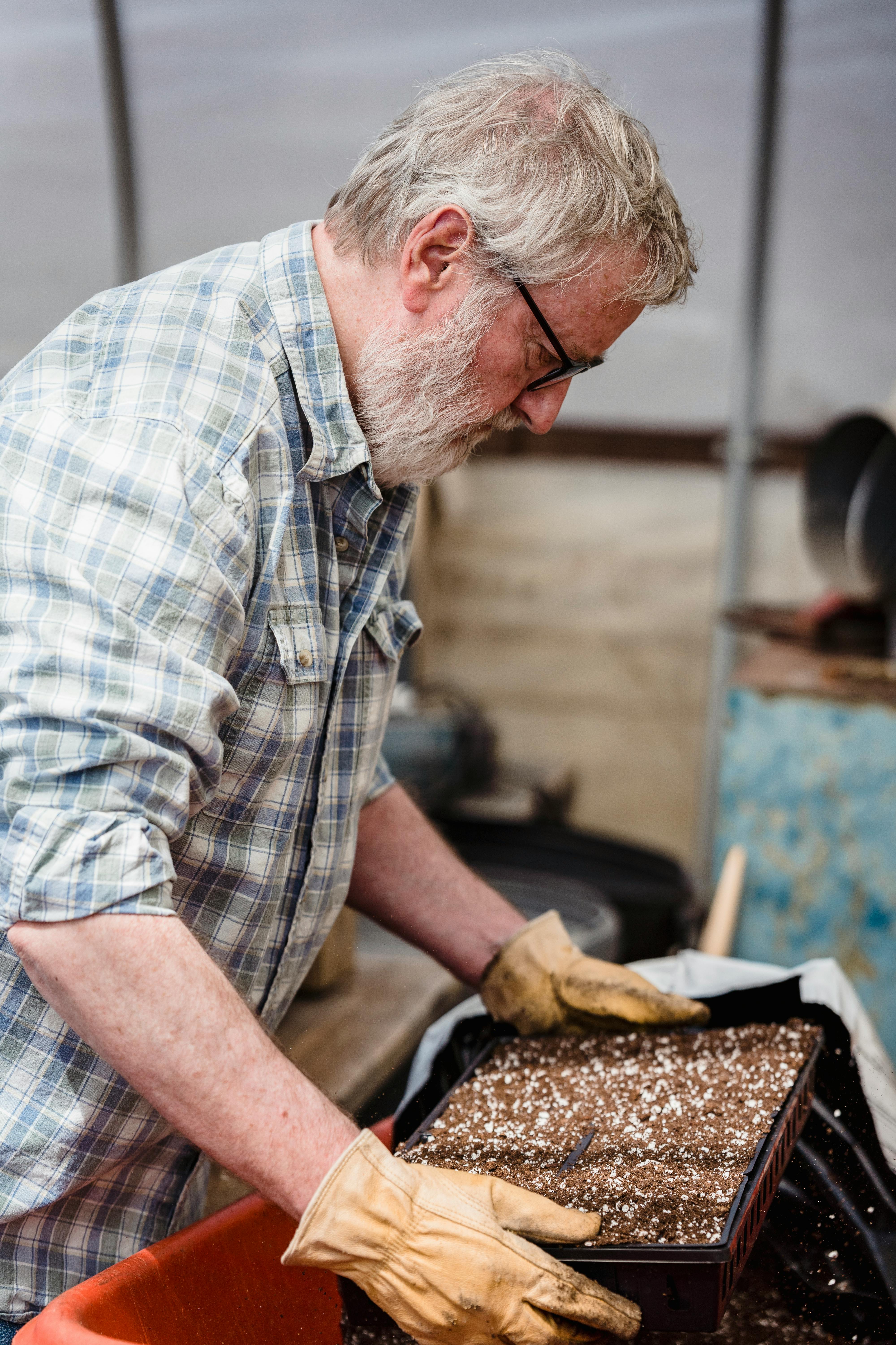 An Elderly Man Holding a Potted Plant