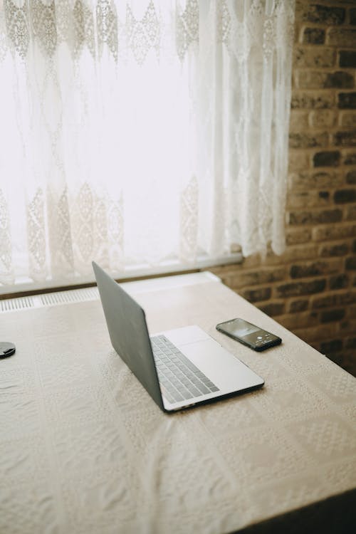 Free Laptop placed on table with white tablecloth Stock Photo