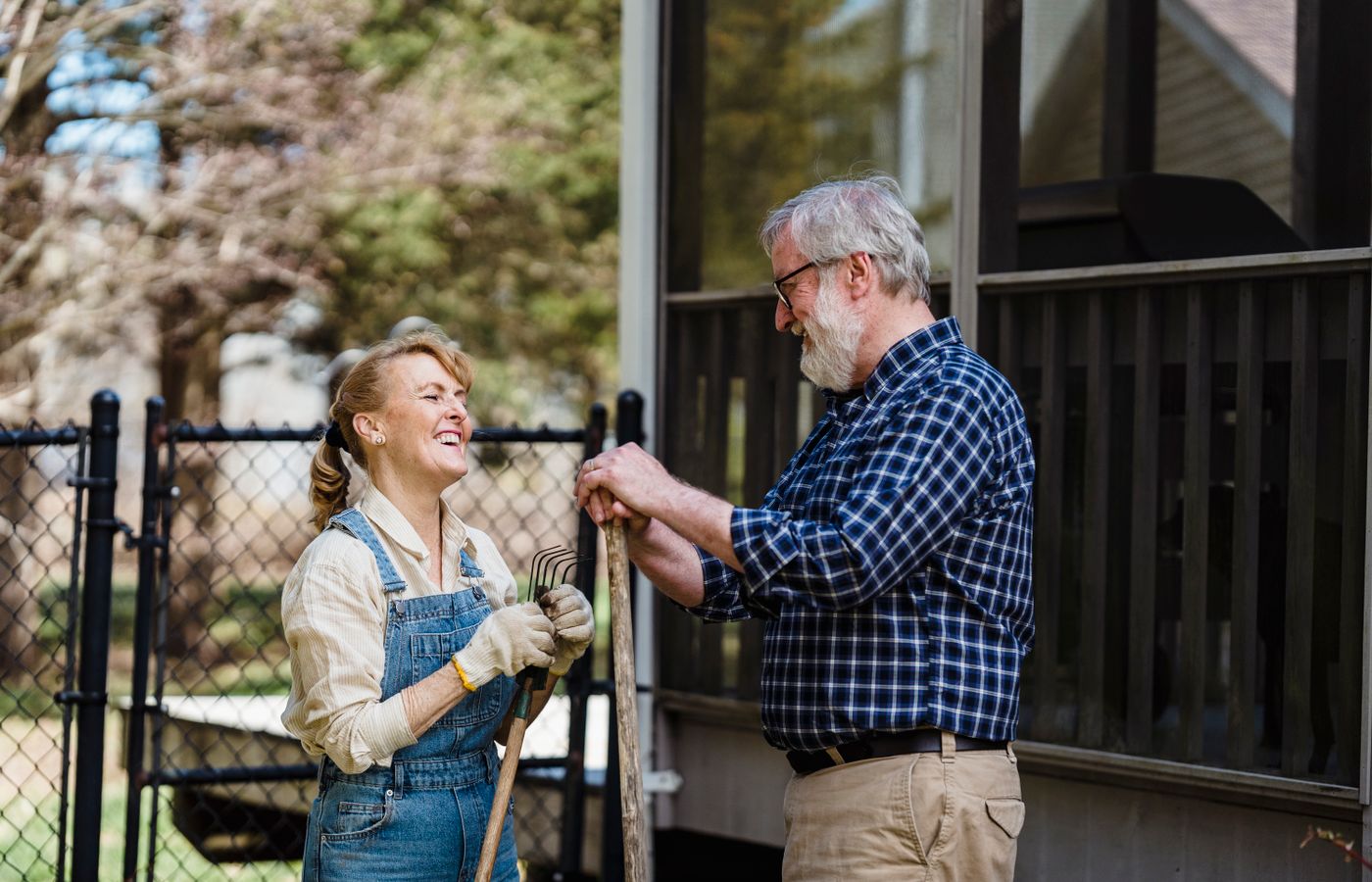 Senior couple gardening together in a sunny garden.