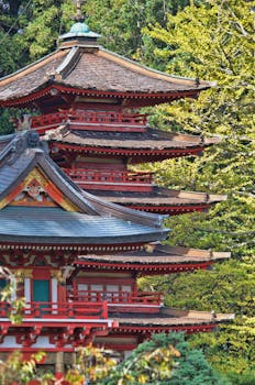 春天，一座令人惊叹的红色木塔矗立在郁郁葱葱的绿树环绕之中，展现了日本传统建筑的风采