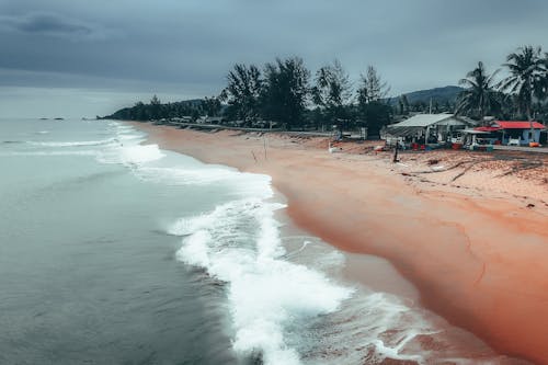 Foamy waves of sea rolling on sandy shore