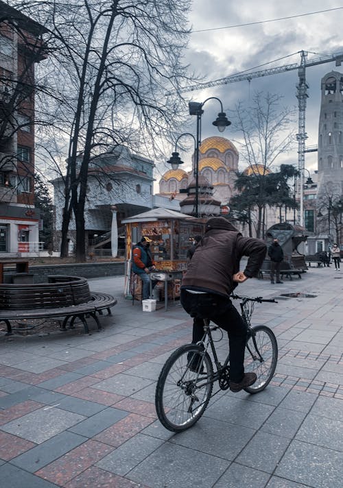 Man Riding Bicycle on Sidewalk