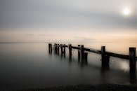 宁静的海景中，木制码头在日落时延伸到平静的大海里