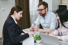 A couple discusses financial documents with their advisor, highlighting investment strategies.