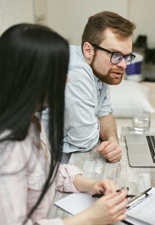 Man Wearing Black Framed Eyeglasses Leaning Forward on Table