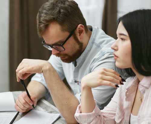 Free A man and woman collaborating on a project in an indoor office environment. Stock Photo