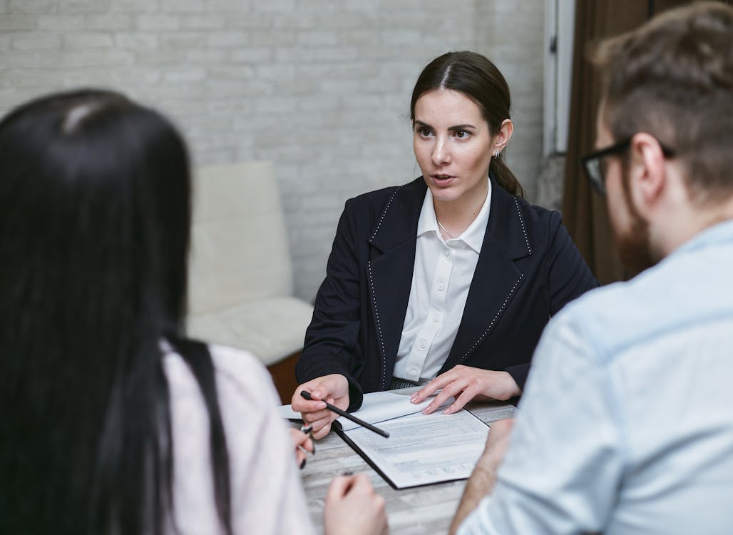 Free Woman in Black Blazer Talking to Her Co-workers Stock Photo