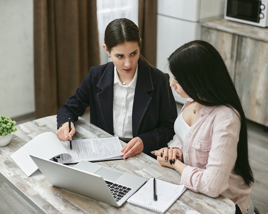 Free Women Discussing About Paperwork  Stock Photo