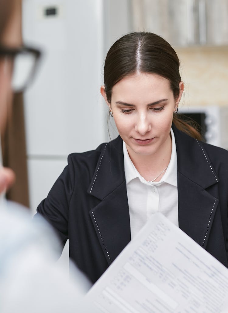 Woman In Black Blazer Holding A Piece Of Document