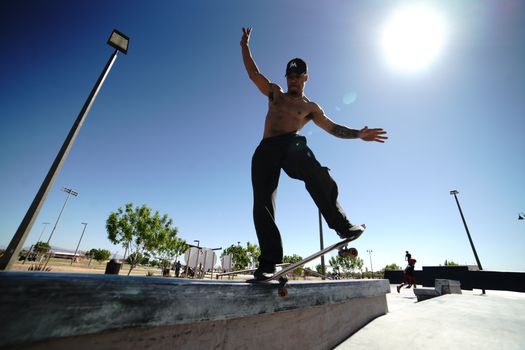 Shirtless Man Balancing on a Skateboard in a Skatepark 