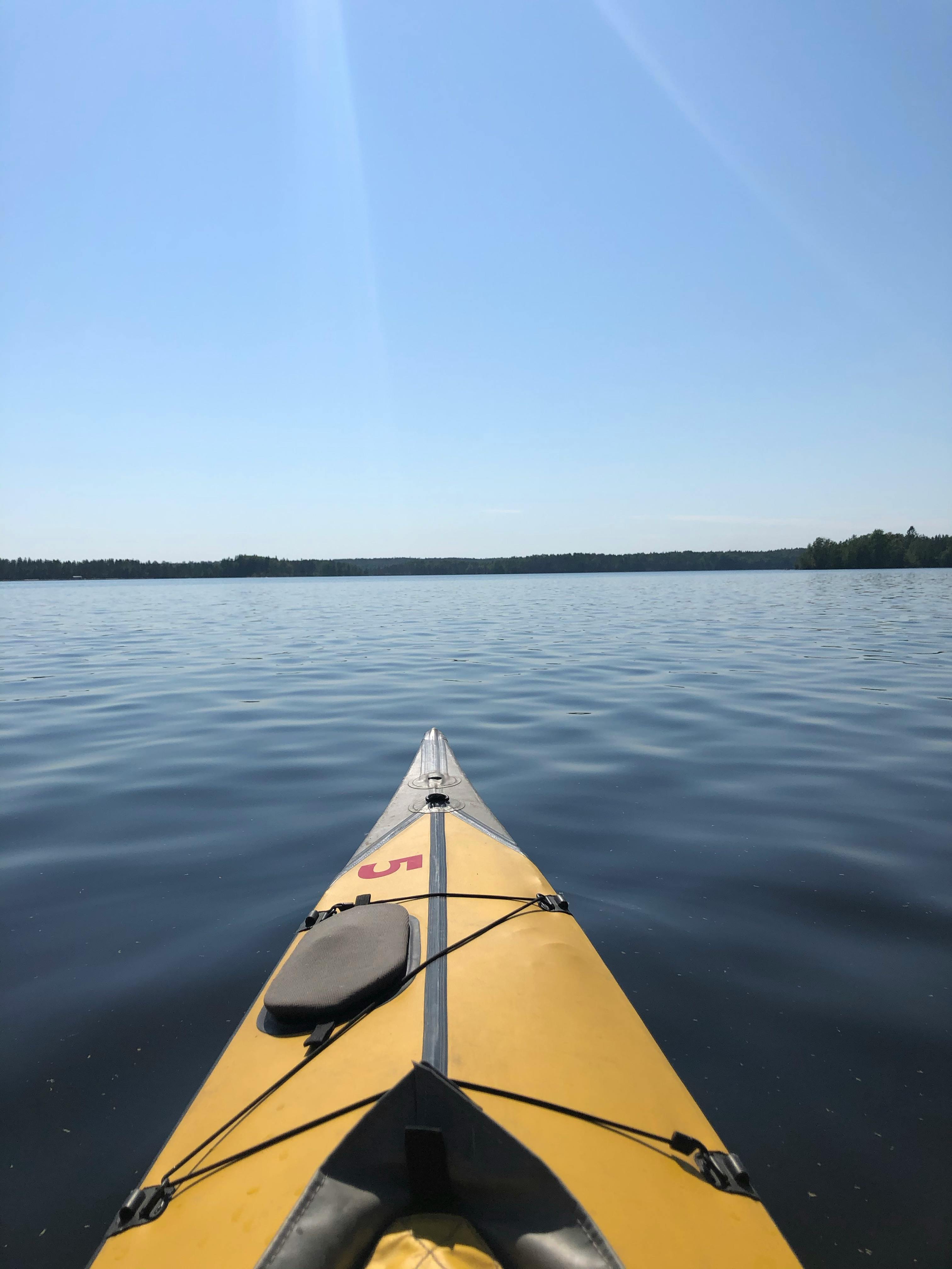 photograph of a black and yellow kayak on a body of water