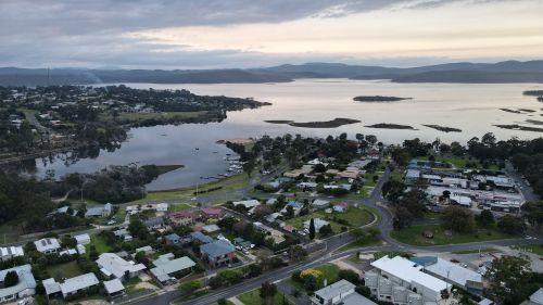 Free Aerial view of Mallacoota, showcasing the serene lake, residential areas, and lush greenery. Stock Photo