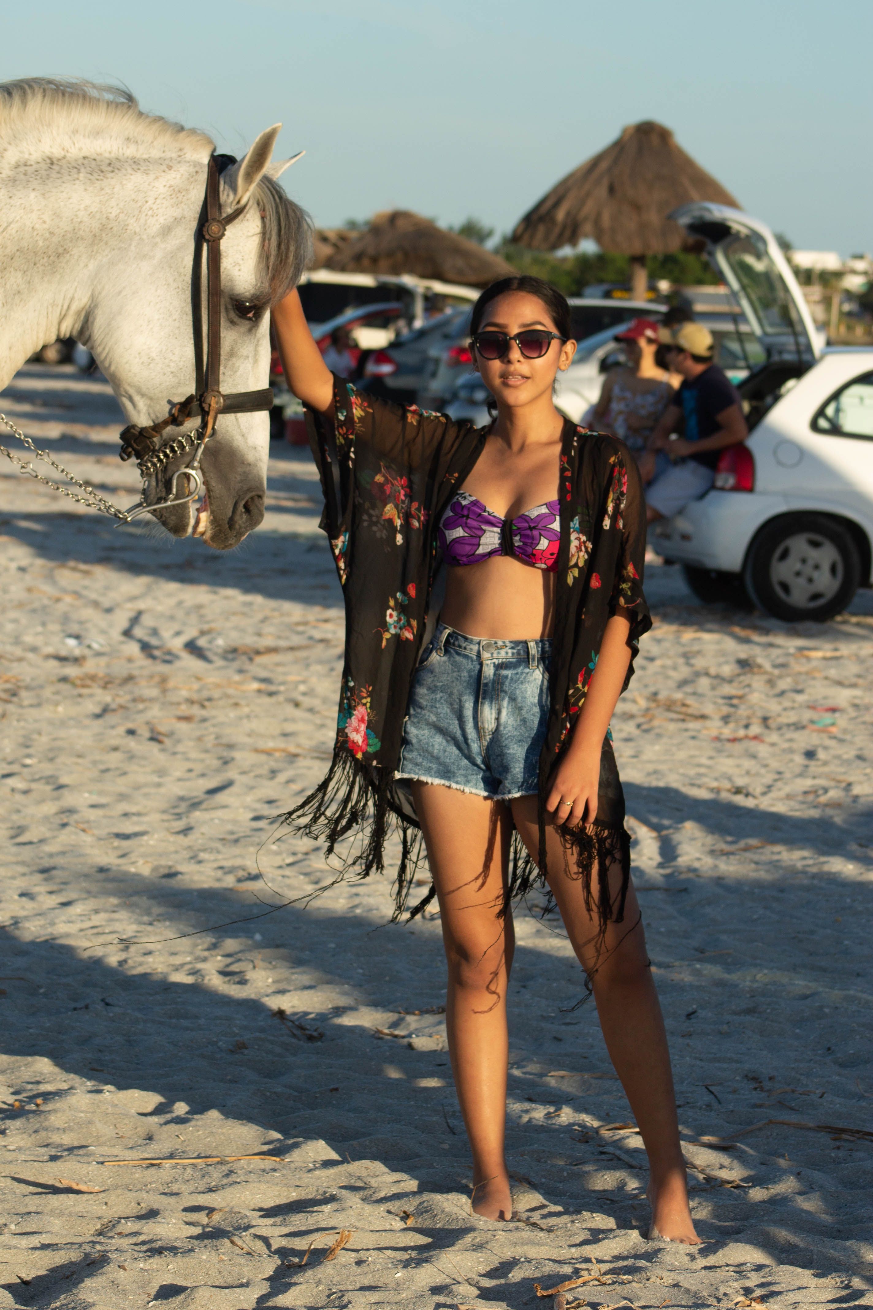 Mulher desfrutando de um dia ensolarado com um cavalo em uma praia mexicana, capturando uma vibe relaxante de verão.