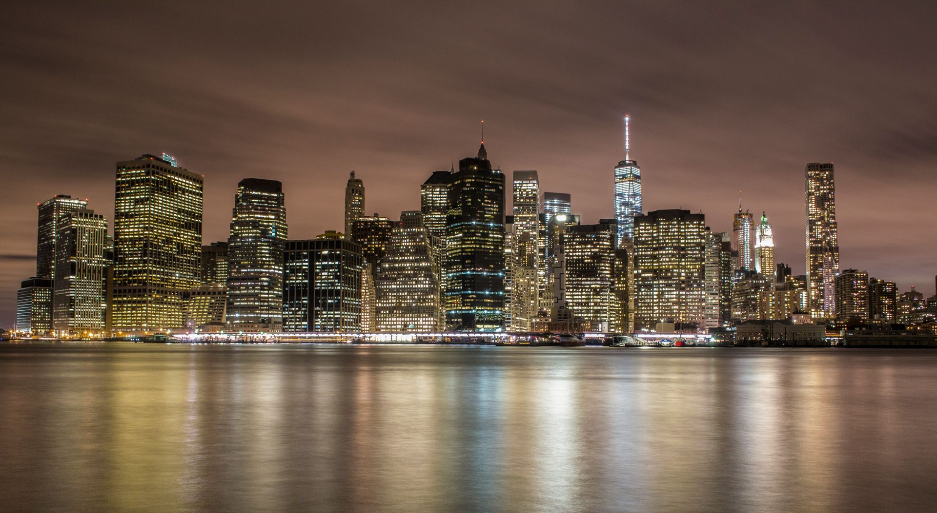 New York City illuminated skyline reflecting on water — AI-powered marketing for Westchester County businesses