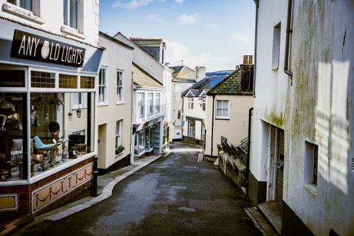 Free A picturesque narrow street lined with quaint shops in a coastal UK town. Stock Photo
