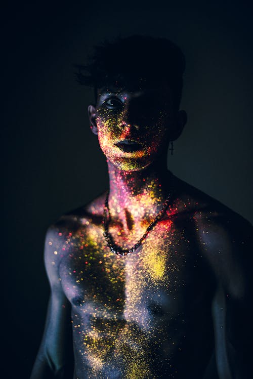 Young shirtless man with glitter