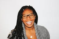 一幅充满活力的肖像中，一位扎着辫子、戴着眼镜的女士微笑着，洋溢着喜悦