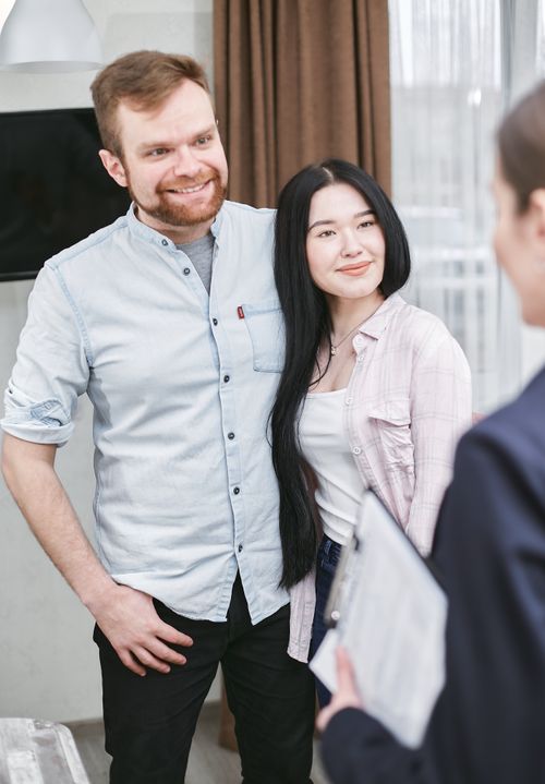 Free Smiling couple meeting with an advisor indoors, in a professional setting. Stock Photo