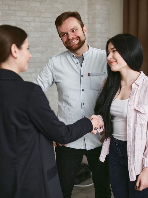 Free Three adults shaking hands in a professional meeting setting, showing agreement and positive interaction. Stock Photo