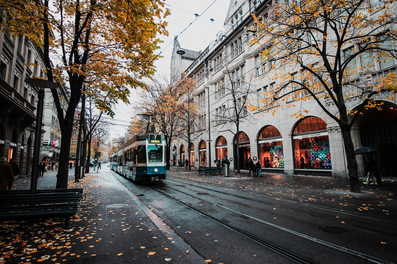 Bahnhofstrasse in Zürich im Herbst, Tram und klassische Geschäftsfassaden im Morgenlicht.