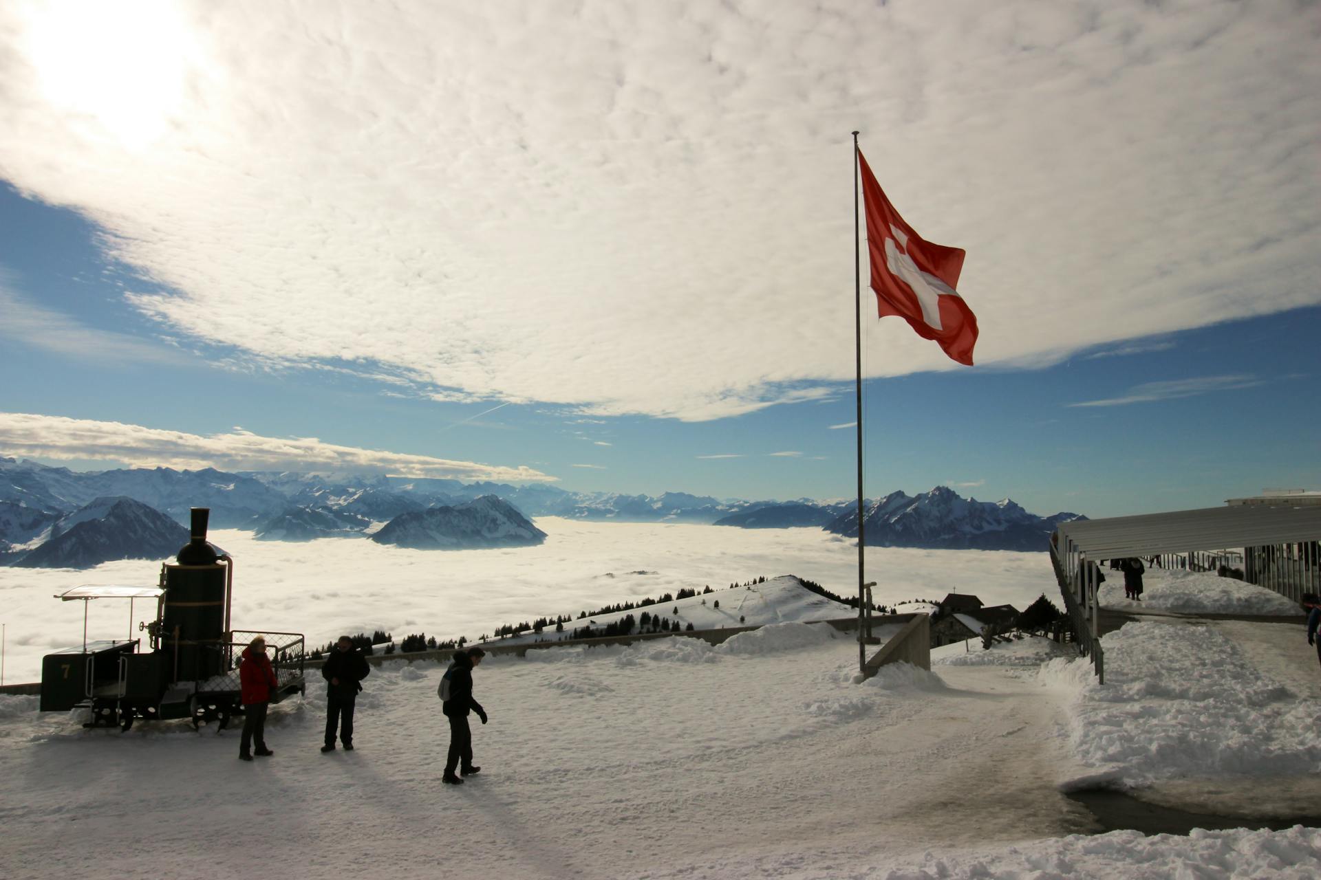 High-saturated Silhouette Photography of Three Person Standing Near Red and White Cross Printed Flag