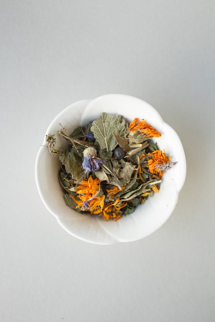 Dried Leaves And Flowers On Ceramic Bowl