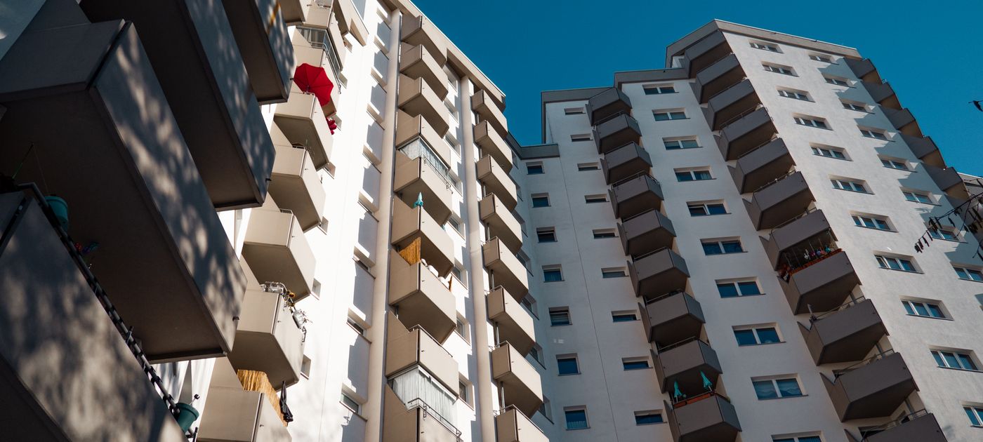 A modern residential apartment building — pests spread building-wide from shared common areas, not unit by unit