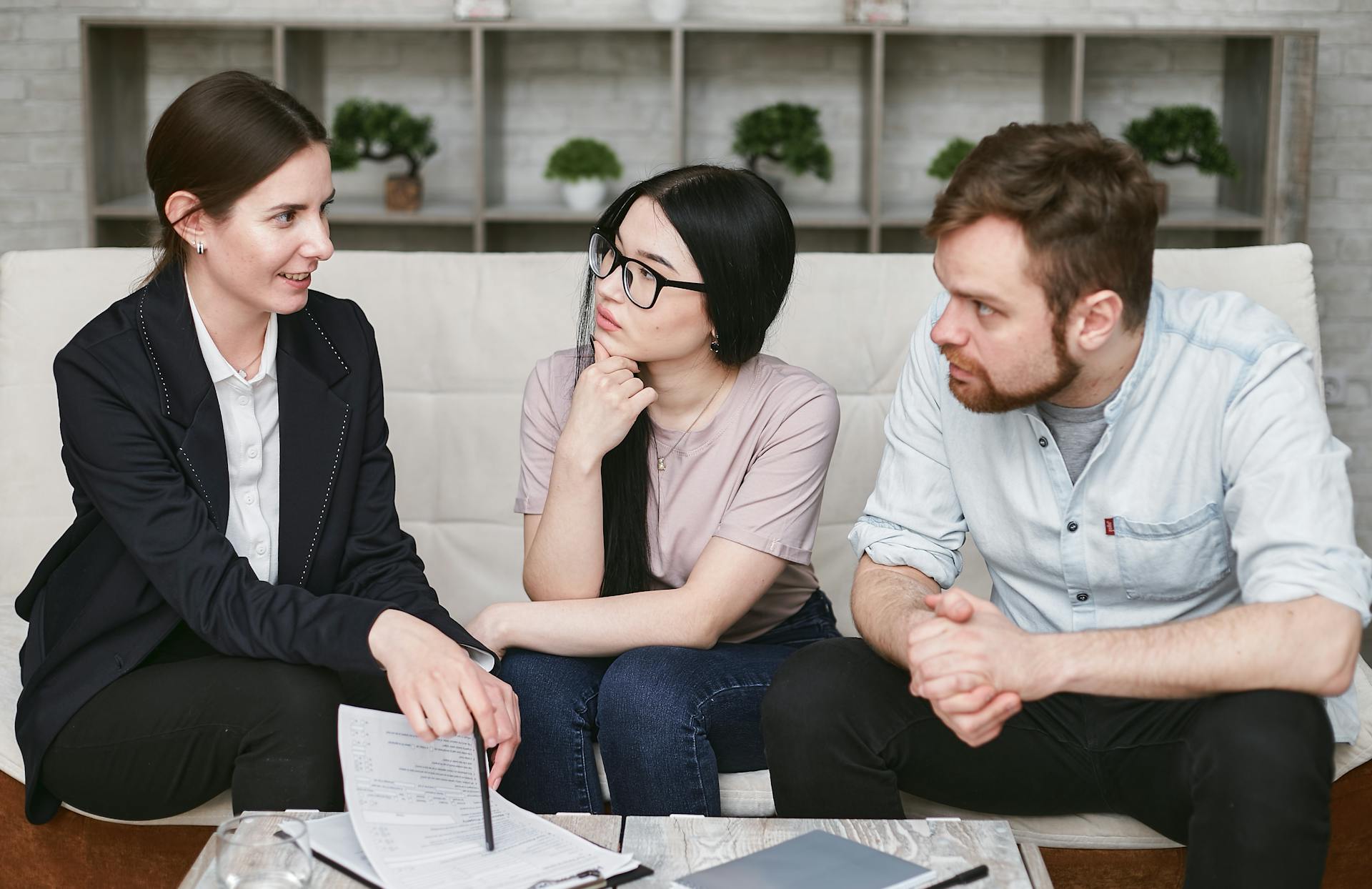 Three adults discussing business inside, focused on cooperation and strategy.