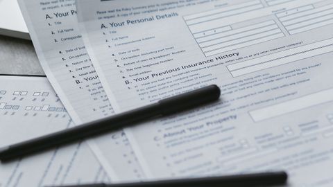 Close-up of home insurance documents with a laptop for financial planning.