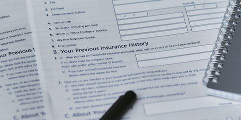 Flatlay image featuring a home insurance policy form and a notebook, shot from above.