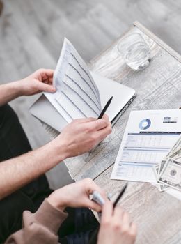 Two professionals reviewing financial documents with charts, fostering collaboration.