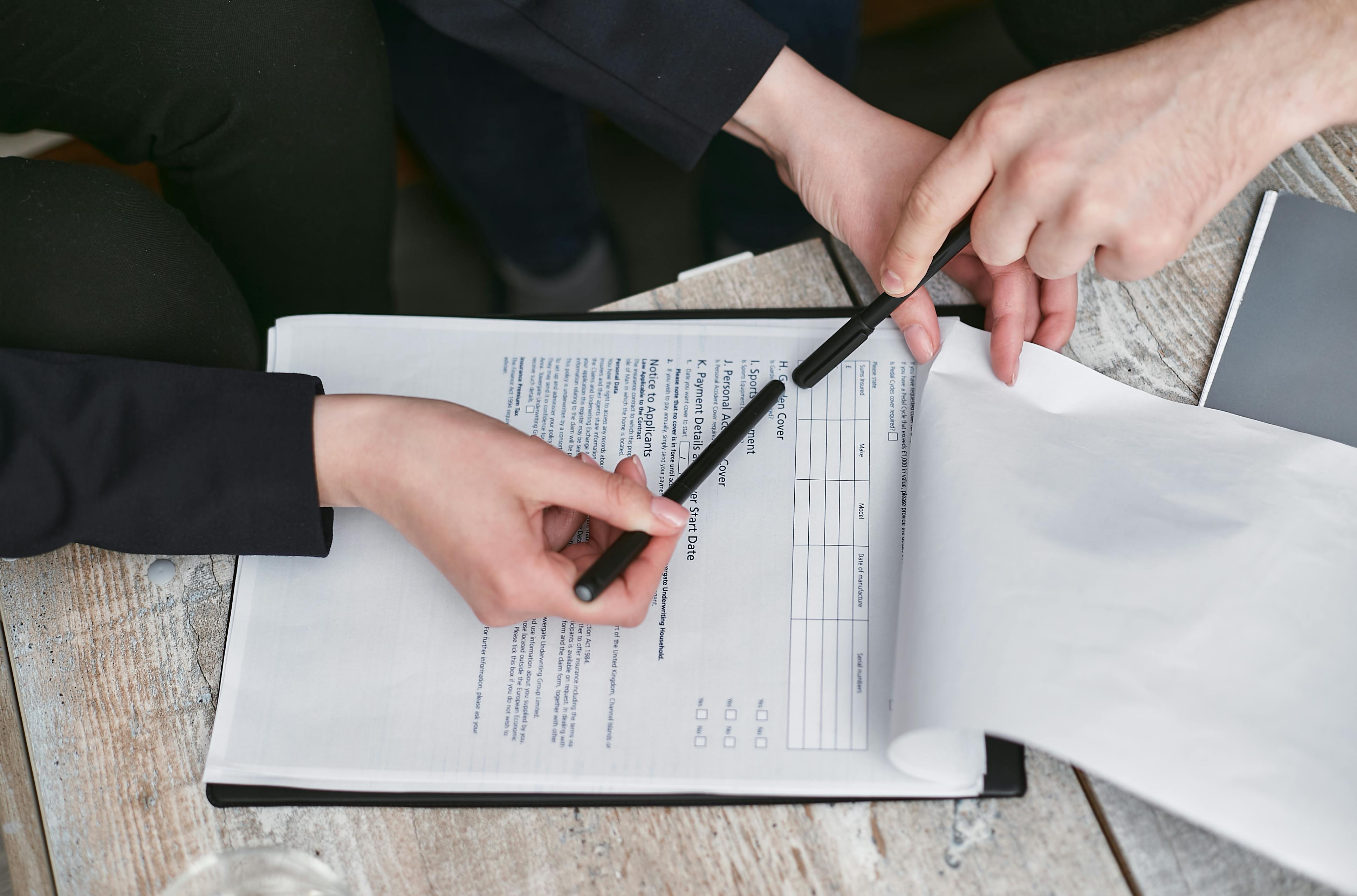 Free Person Holding Black Pen Reviewing a Document Stock Photo