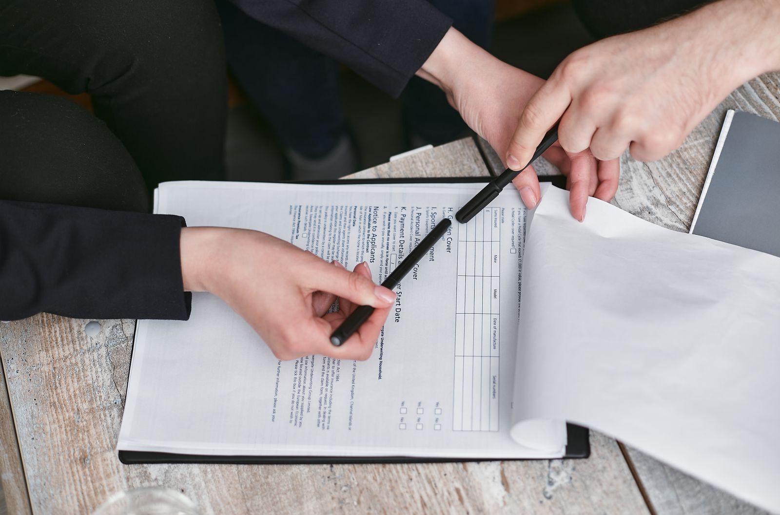 People reviewing employment and legal paperwork at a desk