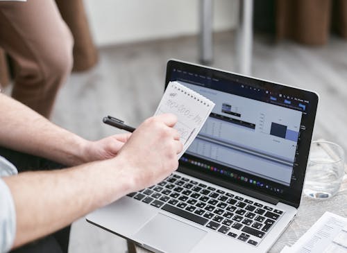 Person Holding Black Pen and Notepad