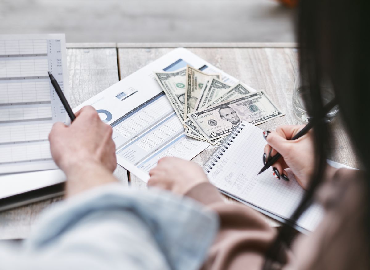 People reviewing financial documents and money at a desk