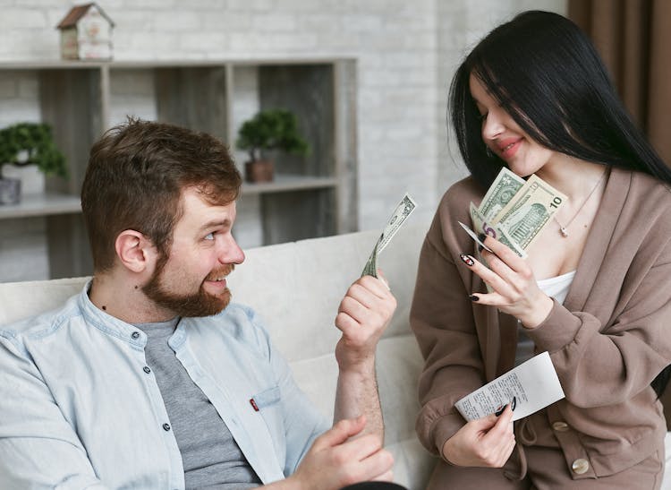 A Man And Woman Holding A Money