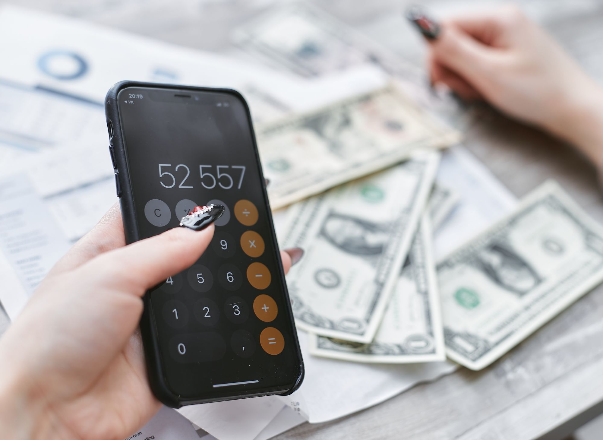 Persona compara pagos mensuales de un teléfono y una computadora portátil