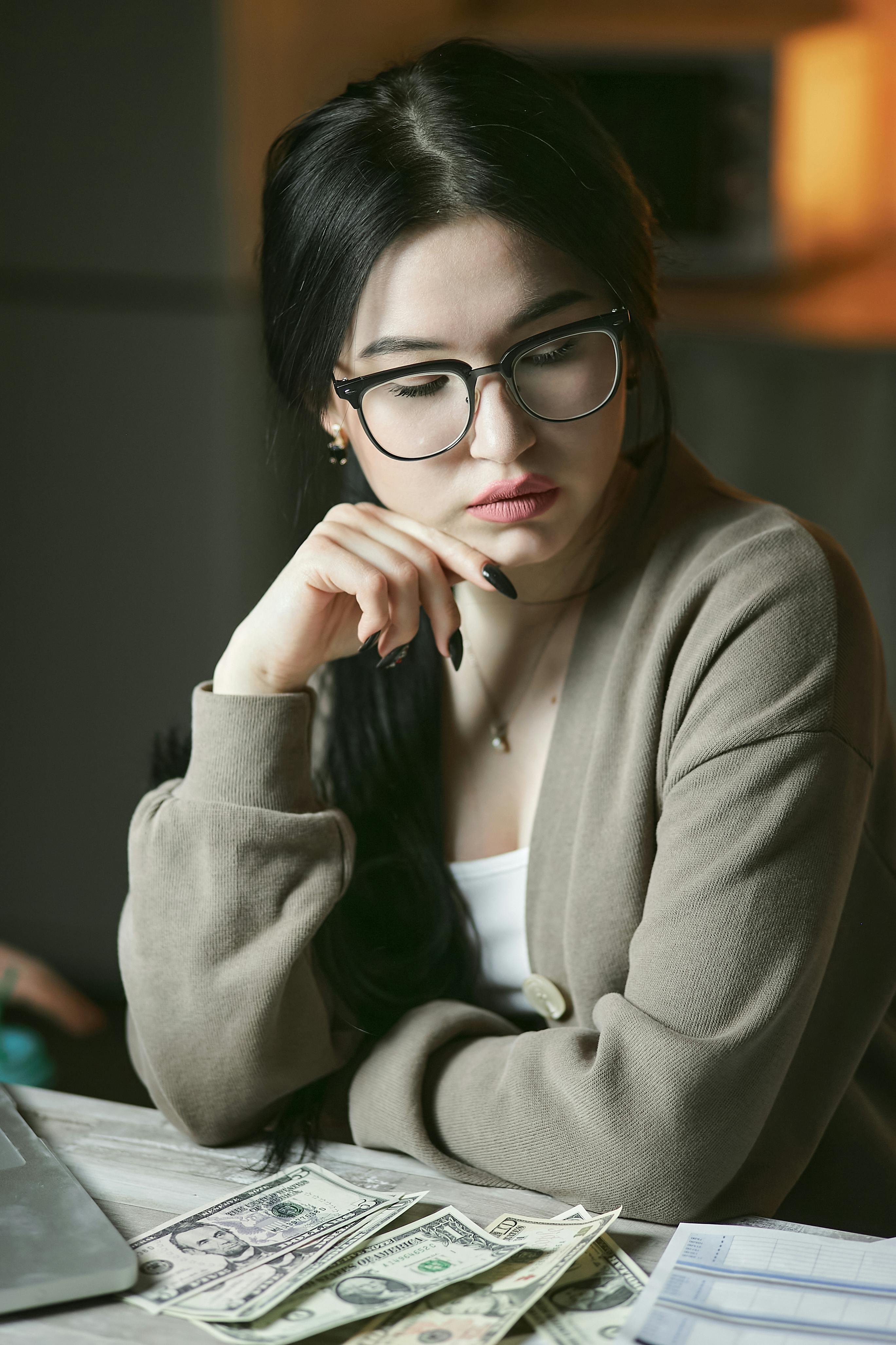 woman in gray sweater wearing black framed eyeglasses