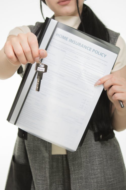 Free Person Holding Key and Insurance Policy Stock Photo