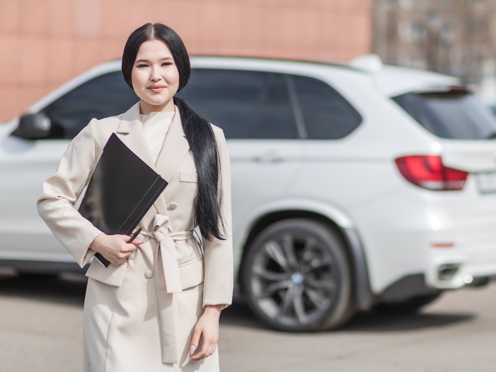 Free Woman in Beige Corporate Clothes Holding Black Folder Stock Photo