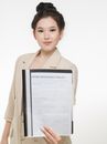 Woman in Brown Coat Holding Insurance Policy Paper