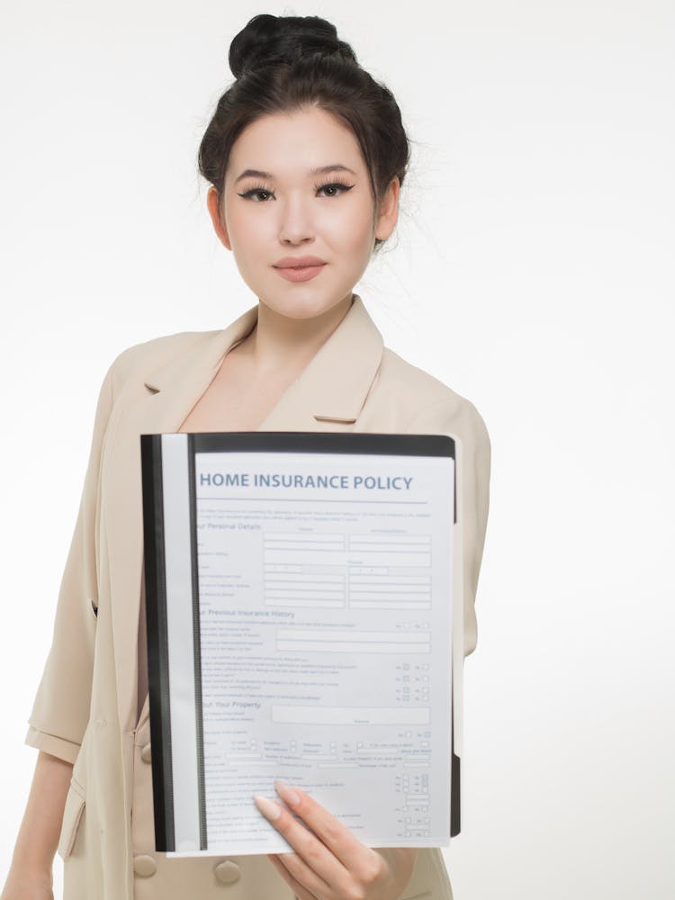 Woman In Brown Coat Holding Insurance Policy Paper