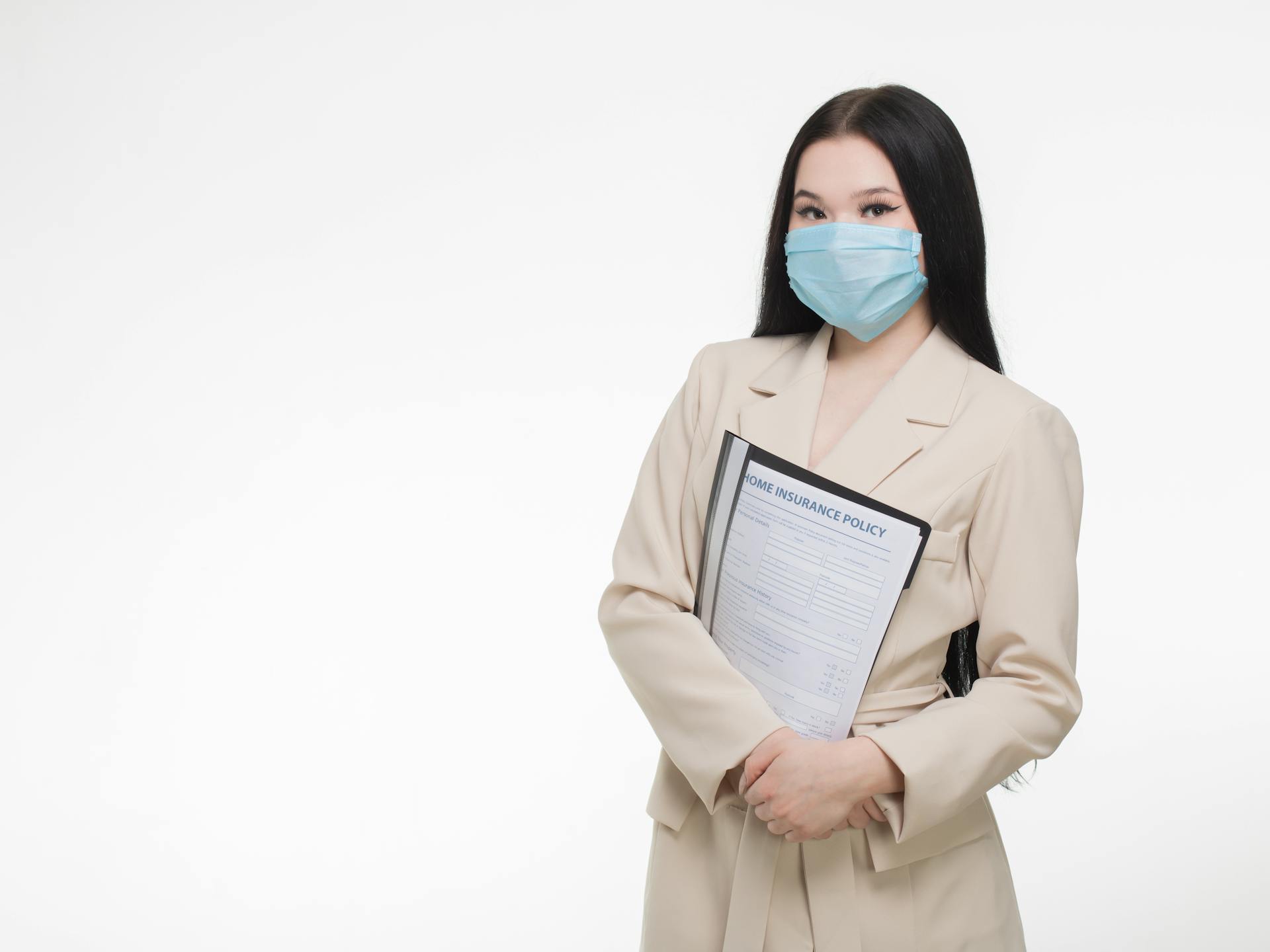 A Woman wearing Face Mask holding Insurance Policy