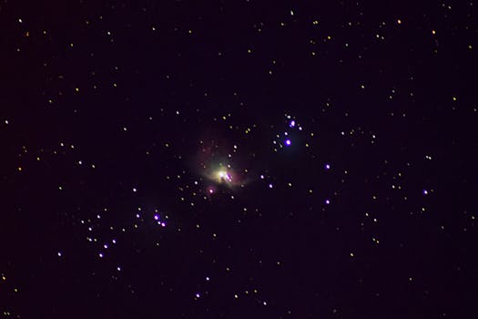 Vivid capture of the Orion Nebula amidst a star-filled night sky, showcasing cosmic beauty.
